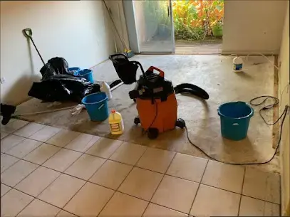 Tile floor with a wet vacuum and buckets after water came in a back door in Pico Rivera, CA